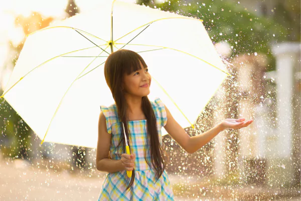 A girl holding an umbrella under the rain