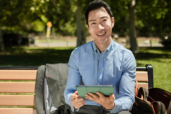 A man smiling sitting on a bench